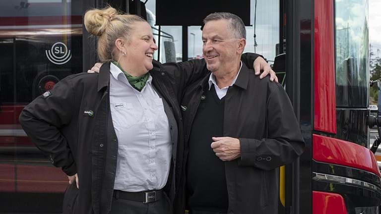 Två bussförare framför en röd SL-buss